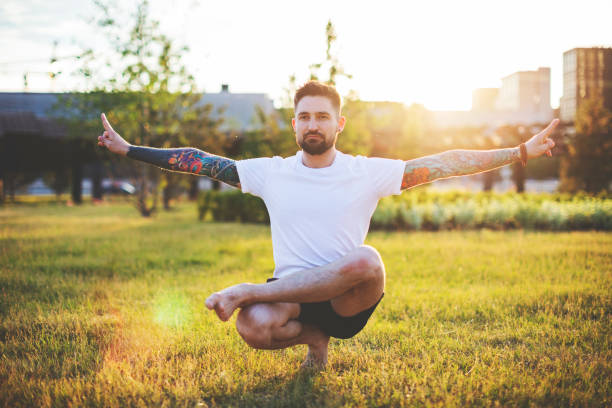 istock Tattooed man practicing yoga outdoors 1157590578