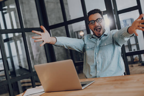 istock Delighted guy is getting good news on laptop 1157590922