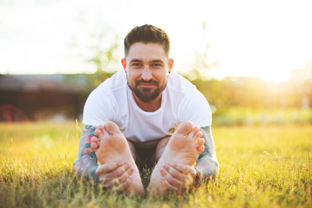 istock Tattooed man practicing yoga outdoors 1157591000