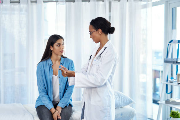It's important that you follow these steps Shot of a young woman having a consultation with her doctor women's clinic stock pictures, royalty-free photos  images