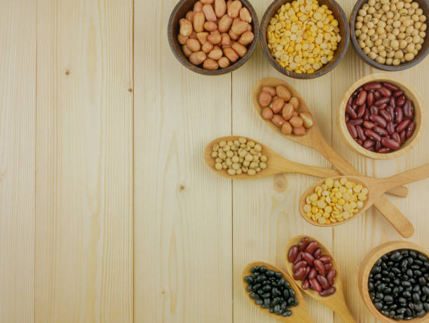 Flat lay,top view assorted beans including red bean,soybeans,black beans,mung beans on brown,beige wooden background with copy space