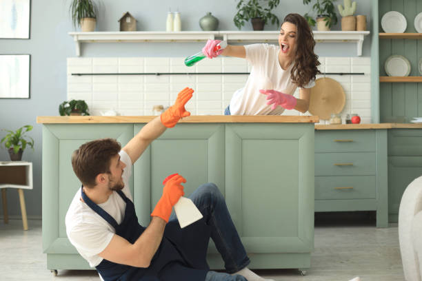 istock Young happy couple is having fun while doing cleaning at home. 1157597239