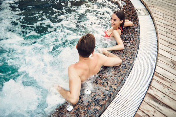 istock Lovely couple spending time in the swimming pool 1157598395