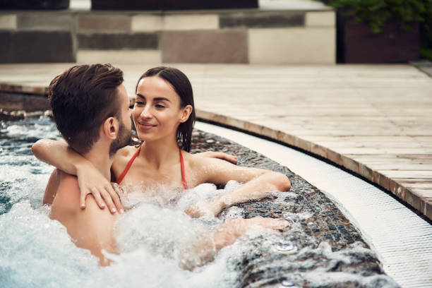 istock Couple in swimming pool looking to each other 1157598405
