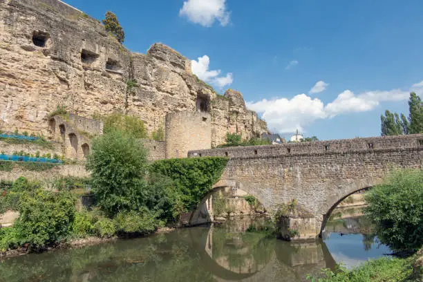 Bridge over Alzette river in Luxembourg city and view at medieval fortification wall