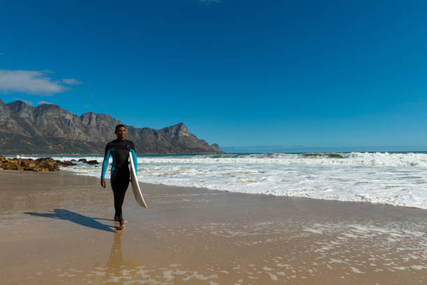 istock Teenage boy with surfboard at beach 1157599763