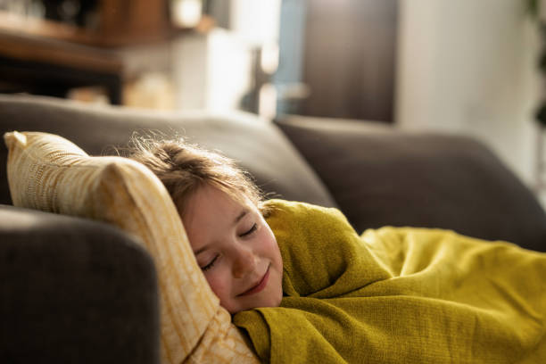 istock Cute little girl napping on the sofa at home. 1157599877