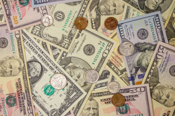 istock Background of different american dollars bills and coins 1157601116
