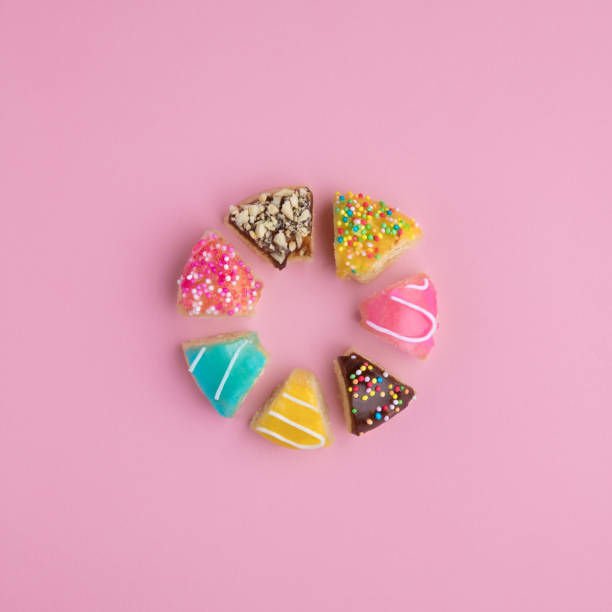 istock Donut shape made of cut donut slices on pink background. 1157606190