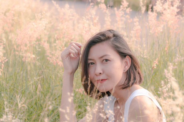 istock Woman sitting in the grass field 1157612733