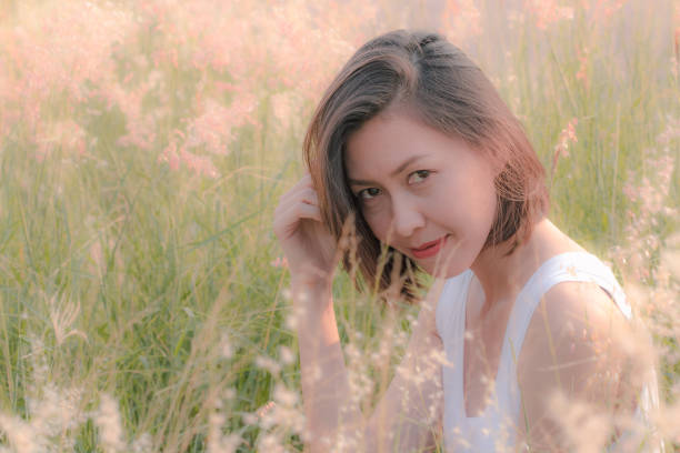 istock Woman sitting in the grass field 1157612778