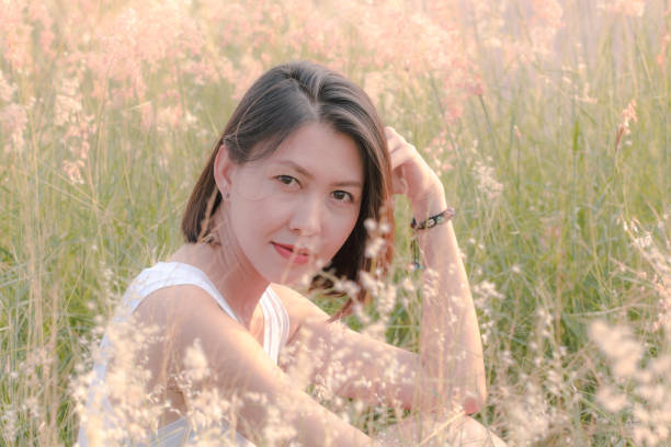 istock Woman sitting in the grass field 1157612819
