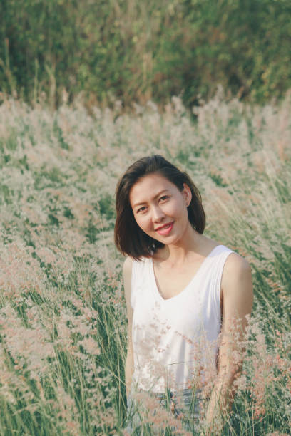 istock Woman sitting in the grass field 1157612845