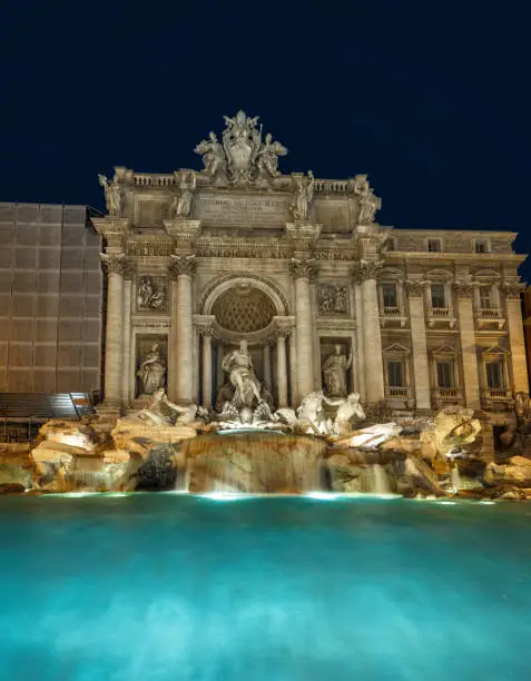 Trevi Fountain at night, Rome, Italy. Fontana di Trevi is one of the top tourist attractions of Rome. Ornate Baroque architecture in the Rome city center. Old beautiful landmark of Rome at dusk.