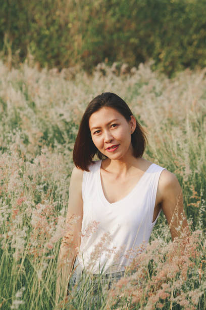 istock Woman sitting in the grass field 1157612933