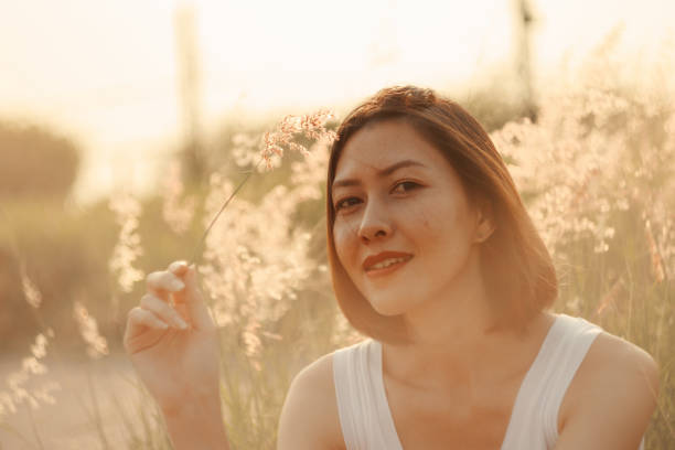 istock Woman sitting in the grass field 1157613019