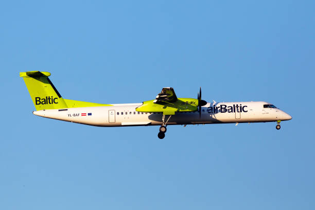 yl-baf air baltic de havilland canada dhc-8-400 aircraft in the sunset rays on the blue sky background - fuel and power generation air vehicle repairing airplane imagens e fotografias de stock