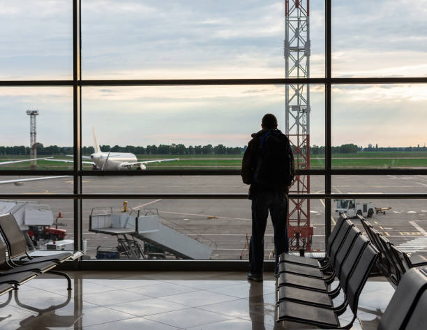istock Man with a backpack looks at the planes 1157614322
