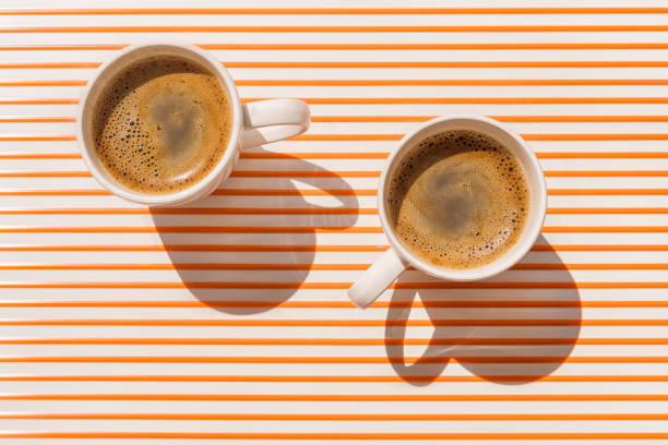 two white coffee cup on orange striped table top view - espresso table coffee cafe imagens e fotografias de stock