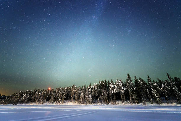 ciel de nuit avec beaucoup d'étoiles au-dessus d'un paysage enneigé avec une forêt et un lac gelé, suède, laponie - lake night winter sky photos et images de collection