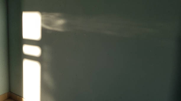 istock Empty room corner and bright shiny blurred sunbeams look like spotlight in darkness. Sunlight rays on grey rough wall background. Light and shadow backdrop. Grunge textures. 1157619292