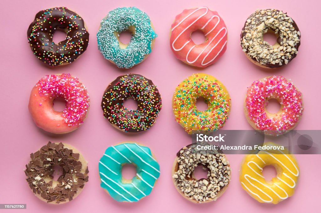 Colorful sweet background. Delicious glazed donuts on pink background. Colorful sweet background. Delicious glazed donuts on pink background Doughnut Stock Photo