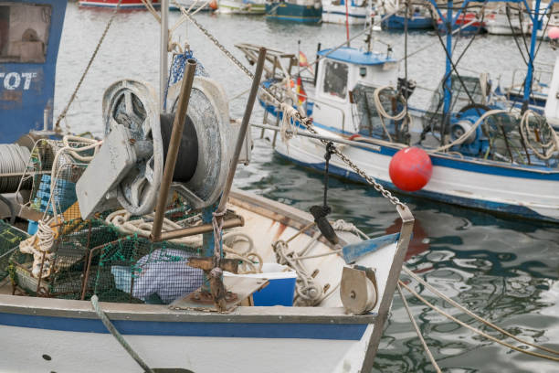 View of the boats with fishing gear in the port. View of the fishing boats in the port. Mooring of the small fishing vessel at the dock. Fishing gear and equipment on the boat. Preparing to sail. fish trawler stock pictures, royalty-free photos & images
