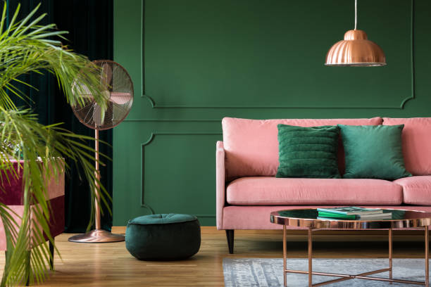 녹색 거실 내부에 구리 램프와 테이블입니다. 실제 사진 - cushion sofa pillow indoors 뉴스 사진 이미지