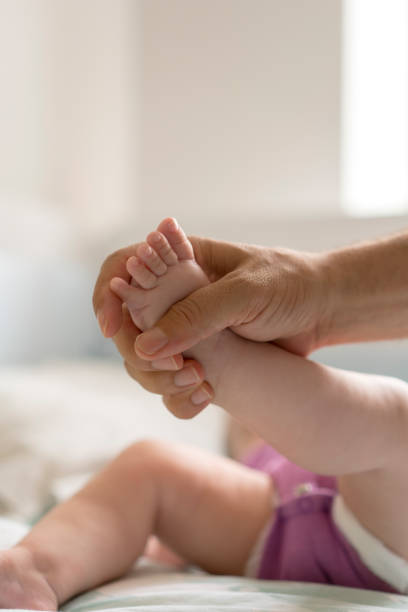 istock Father with newborn baby son legs 1157627479
