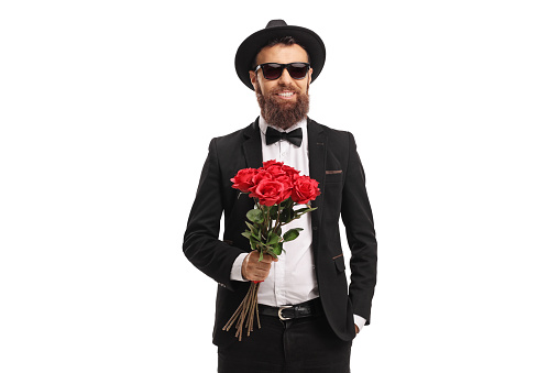 Elegant young man holding a bunch of red roses isolated on white background