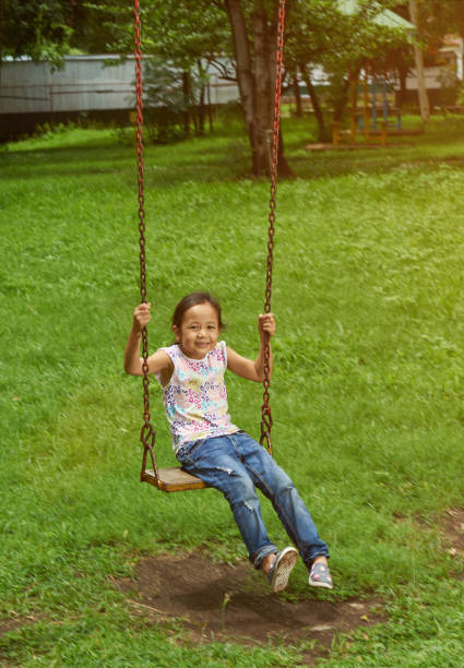 istock Asian girl on a swing 1157629083