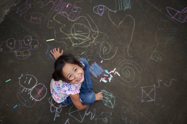 istock Asian girl drawing with chalk 1157629086