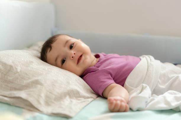 istock Cute baby boy lying in bed 1157632883