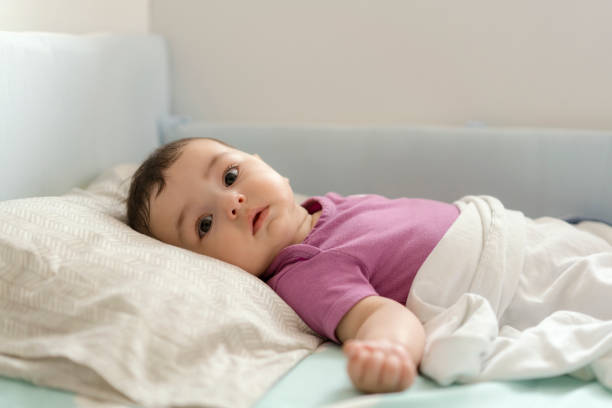istock Cute baby boy lying in bed 1157632886
