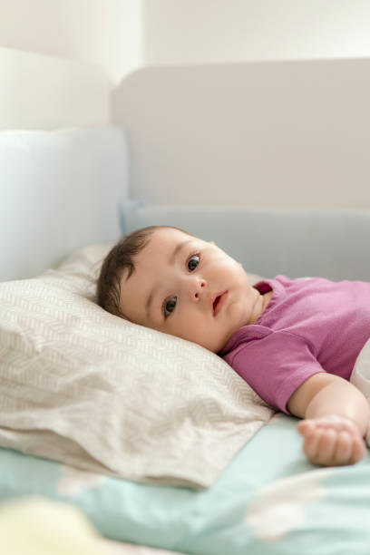 istock Cute baby boy lying in bed 1157632898