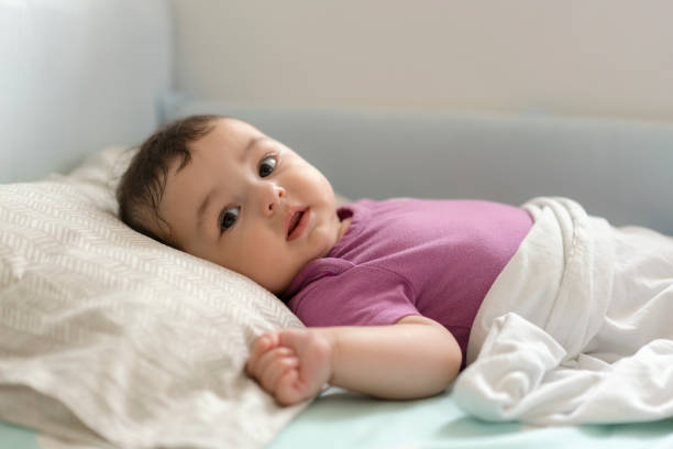 istock Cute baby boy lying in bed 1157632956