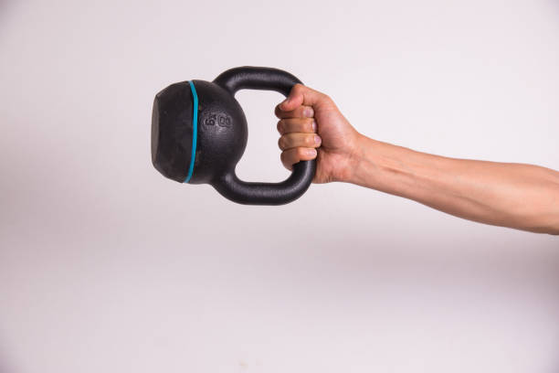 istock Muscular male hand holding old and rusty kettlebell ready for training isolated on a white background, fitness workout concept 1157636050