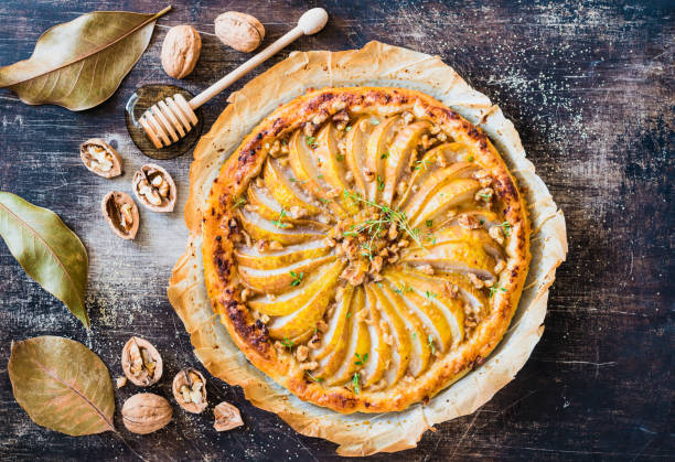 istock Pear tart with nuts and honey homemade pie on rustic dark background. 1157636180