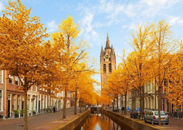 Picturesque dutch scenery with a historic church, a canal, and traditional houses, bathed in warm sunlight
