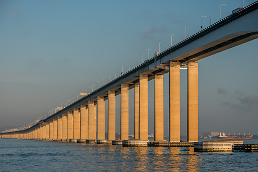 The Rio-Niterói Bridge, seen from the ferry boat with morning light and calm waters.