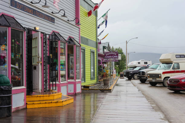 Dawson City, Canada - June 16, 2019. Main Street in Dawson City, lined with tourist shops and cars on a rainy summer day.