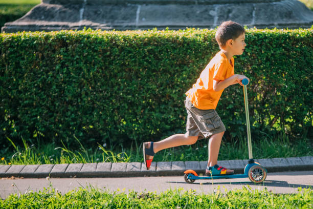 istock Little boy riding a push scooter 1157660856