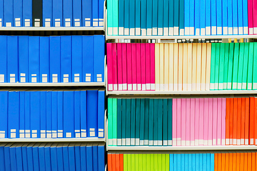 Colorful stack of research books in a university library, with blank book spines. Useful as a background.