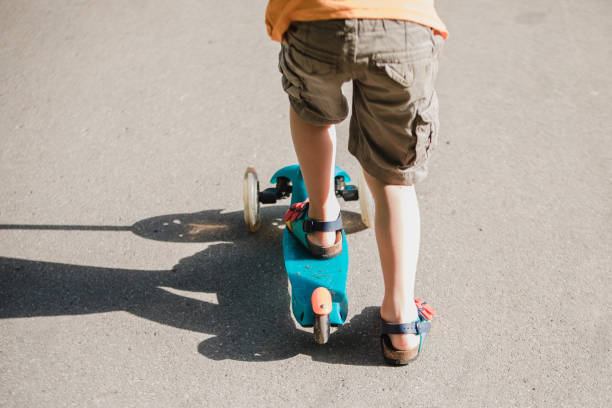 istock Little boy riding a push scooter 1157661876