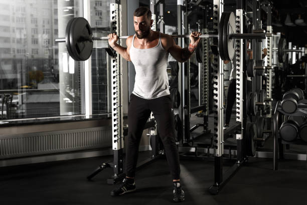 istock Bodybuilding. Bearded man preparing for exercise with barbell at gym sassy 1157662307