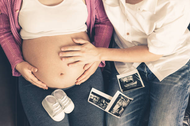 le couple enceinte sent l'amour et se détendre à la maison. - holding men casual mother photos et images de collection