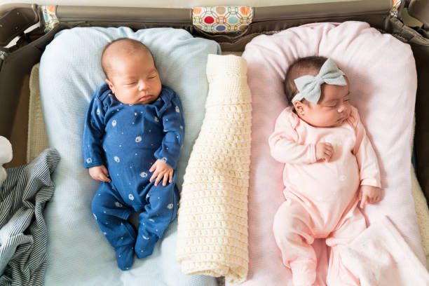 Double Delight High angle view of adorable twin babies sleeping on bed at home blue brothers stock pictures, royalty-free photos & images
