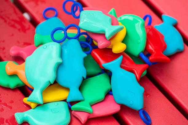 some waterproof multicolor plastic fishes toys on a red plastic board