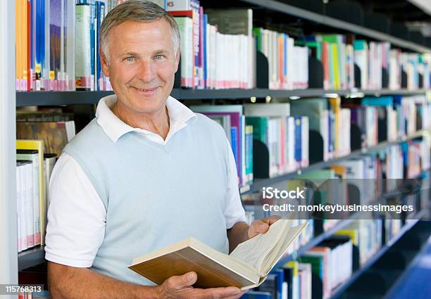 Uomo Anziano Leggendo In Una Biblioteca - Fotografie stock e altre immagini di Terza età - Terza età, Biblioteca, Leggere