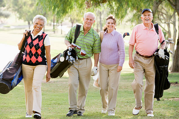 Four Friends Enjoying A Golf Game Four Friends Enjoying A Golf Game Walking Across Course happiness four people cheerful senior adult stock pictures, royalty-free photos & images